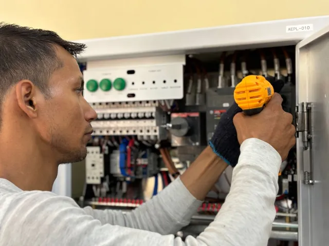 Stock reference: a technician working on an electrical panel.