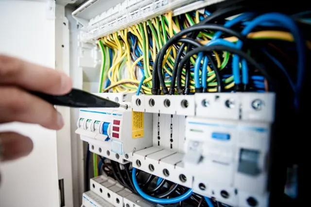 Stock reference: electrical wiring and circuit breakers inside a distribution board.
